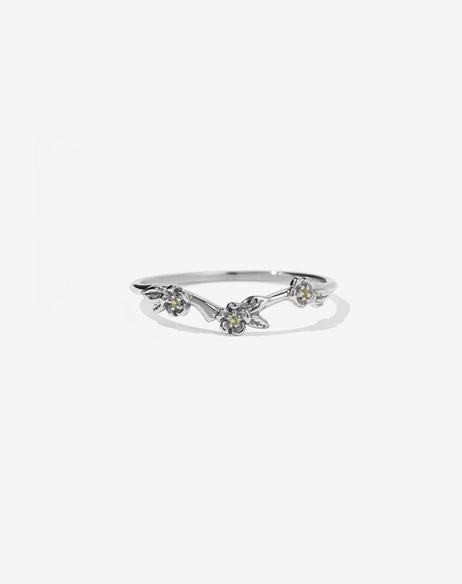 A sterling silver band ring with three flower motifs, each set with a round brilliant stone.