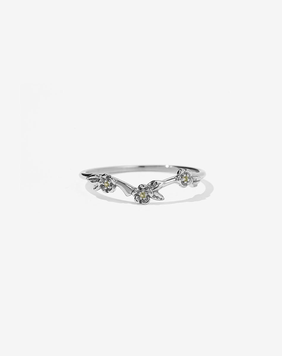 A sterling silver band ring with three flower motifs, each set with a round brilliant stone.