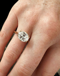 Yellow gold oval east west diamond solitaire engagement ring worn on hand.