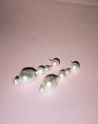 Pearl earrings featuring a series of round and baroque pearls