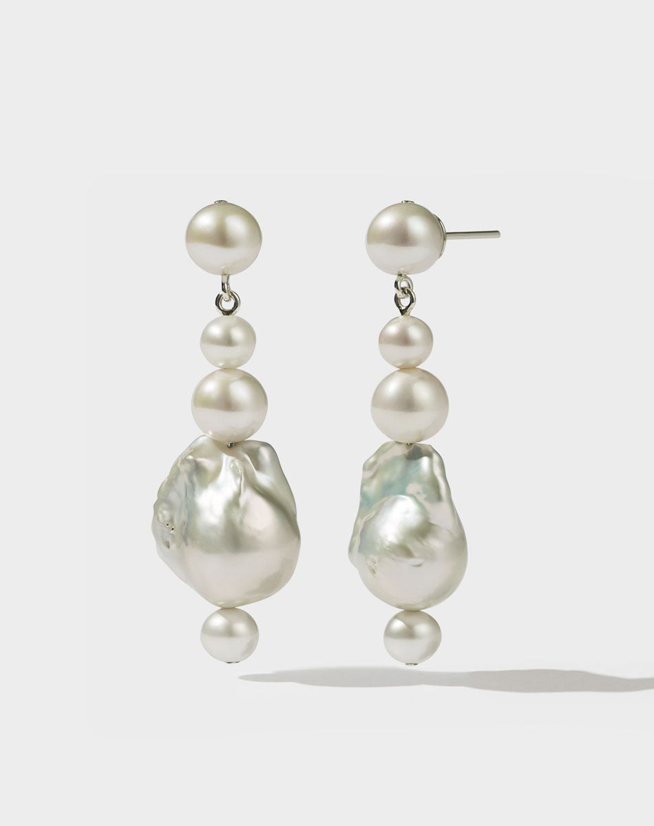 Silver drop earrings featuring a series of round and baroque pearl drops.