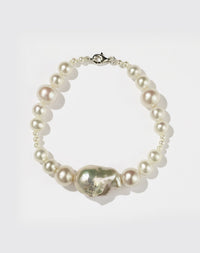 A sterling silver bracelet featuring a string of round and baroque pearls with a silver clasp.