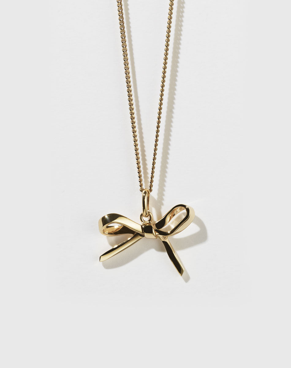 Gold bow charm necklace with a fine chain