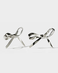 Large sterling silver bow earrings designed to drape across the earlobe.