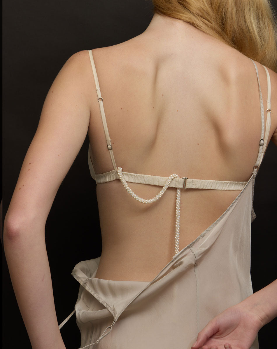 Beige lingerie set with thin straps on a black background