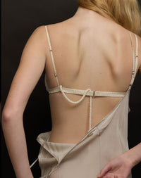 Beige lingerie set with thin straps on a black background