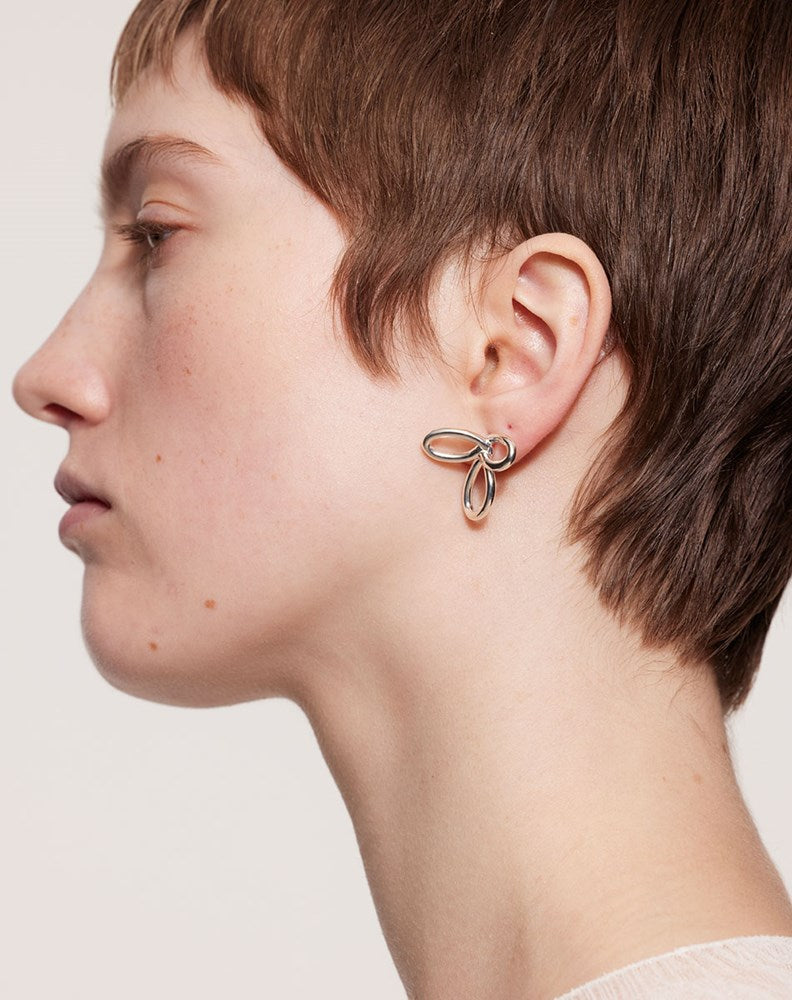 A model wearing the silver flower earrings