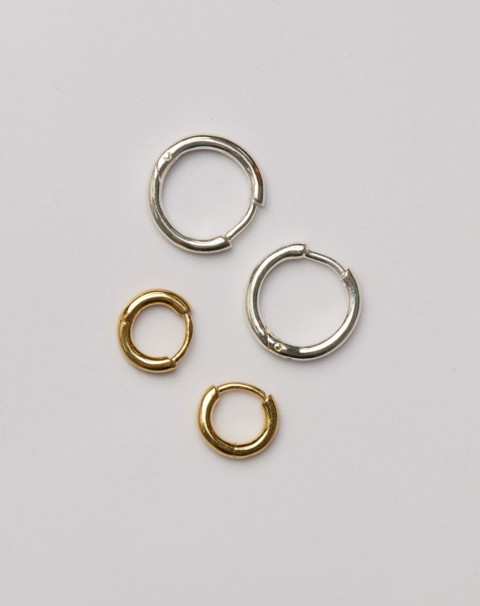 Two pairs of silver and gold huggie hoop earrings 