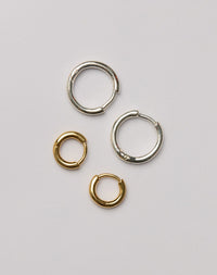Two pairs of silver and gold huggie hoop earrings 