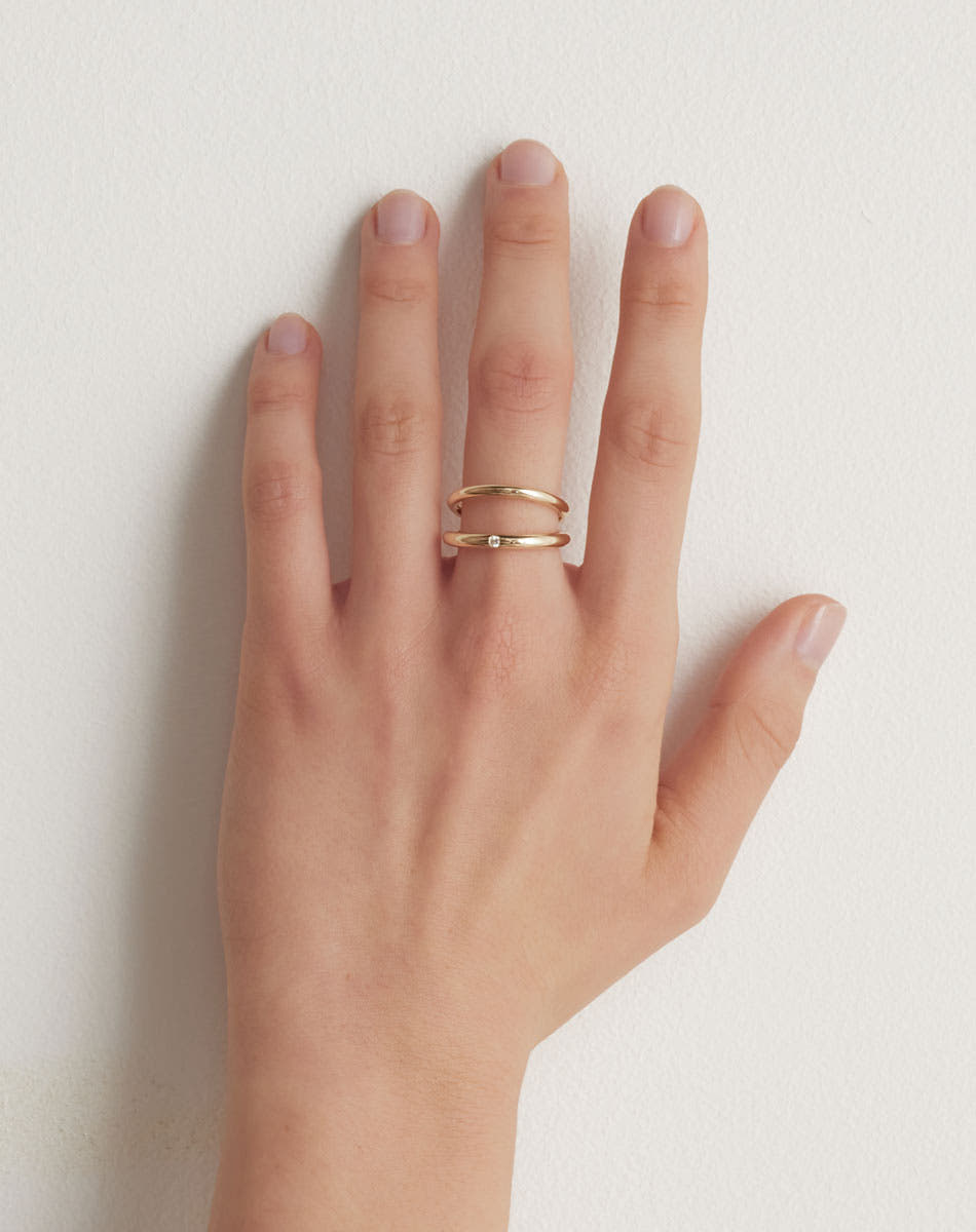 Coco Ring with double bands in 9ct Yellow Gold. Set with round brilliant white diamond. 2.3mm and 2.8mm wide bands. Worn on model hand.