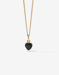 Gold necklace with a black onyx heart-shaped pendant on a white background