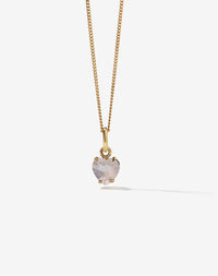 Gold necklace with a heart-shaped rose quartz pendant on a light gray background