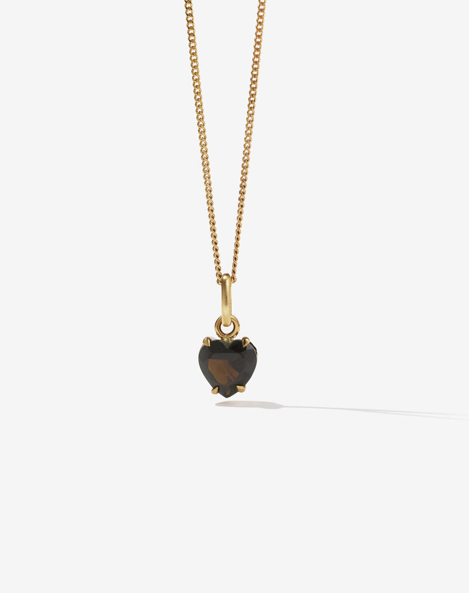 Gold necklace with a heart-shaped smokey quartz stone pendant on a white background