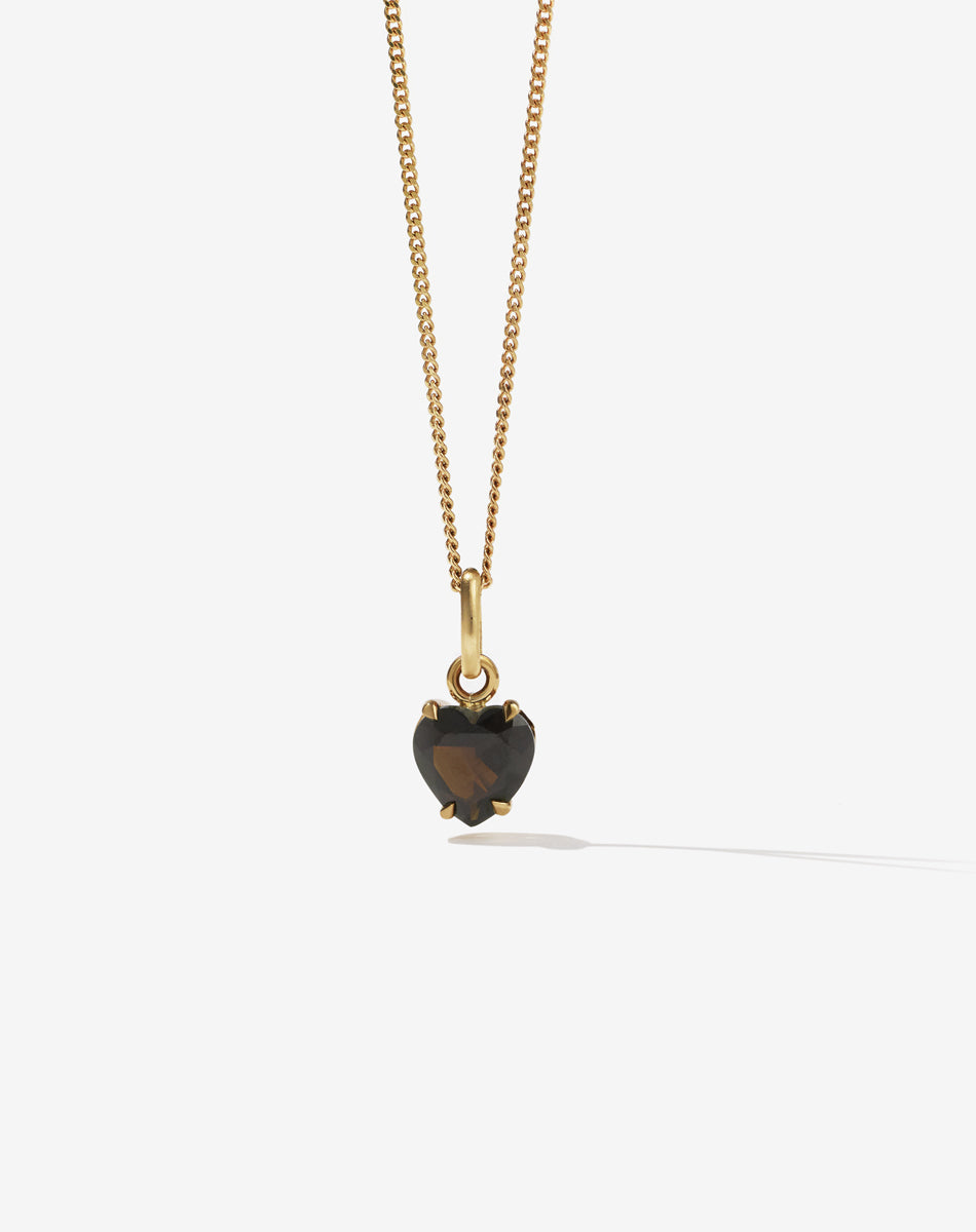 Gold necklace with a heart-shaped smokey quartz stone pendant on a white background