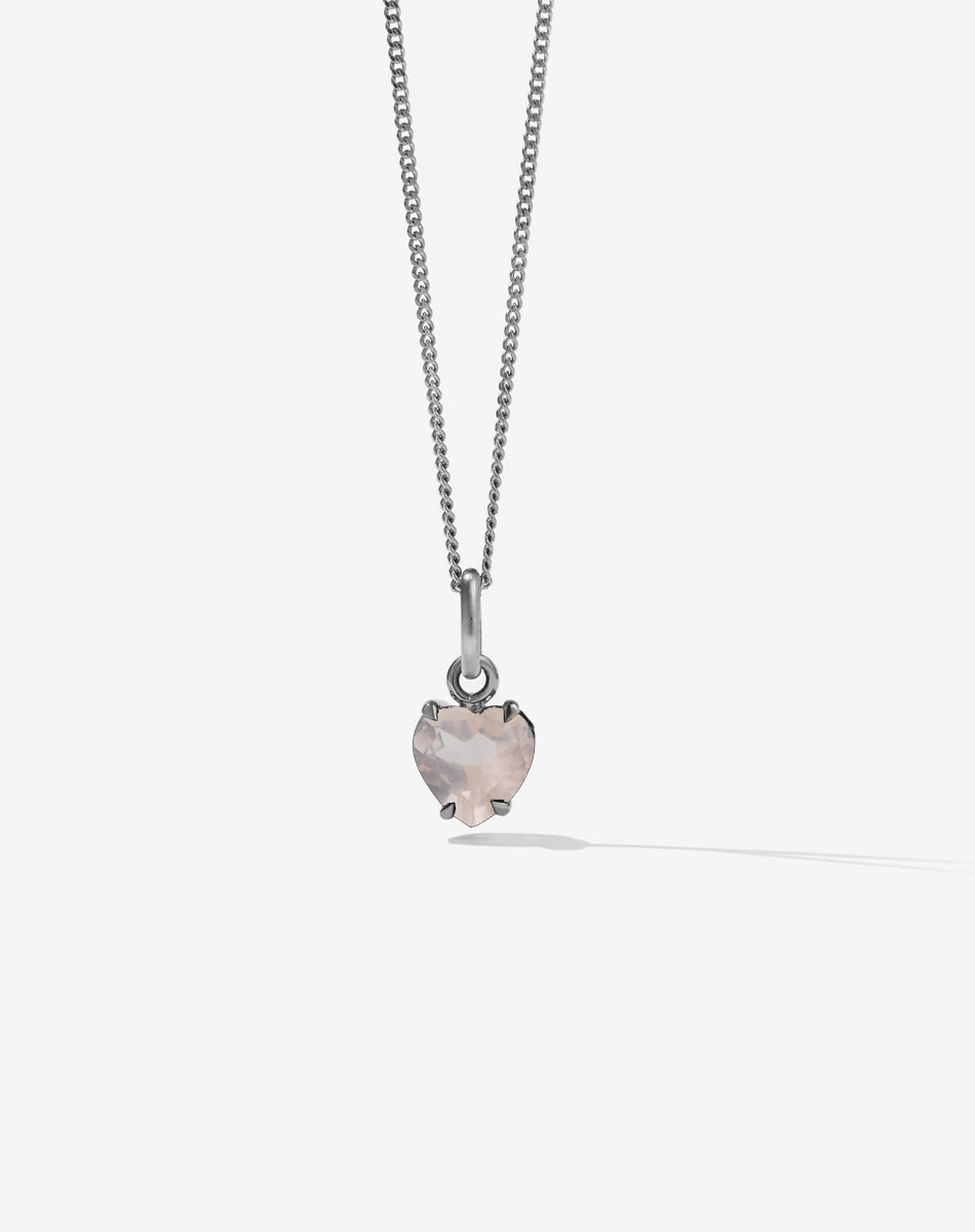 Necklace with a heart-shaped pink rose quartz stone pendant on a light gray background