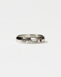 A 9ct white gold band ring with the phrase 'Till Death' engraved on it and a single ruby set in a white gold band.