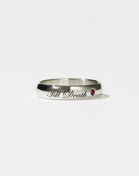 A sterling silver band ring with the phrase 'Till Death' engraved on it, featuring a small ruby on one side.