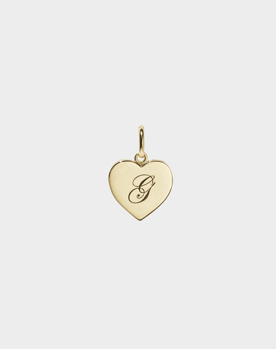 A 9ct solid gold heart-shaped charm with an engraved letter 'G' on it.