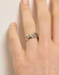 A yellow gold wedding band ring with the phrase 'Till Death' engraved on it and set with white diamonds. On a hand