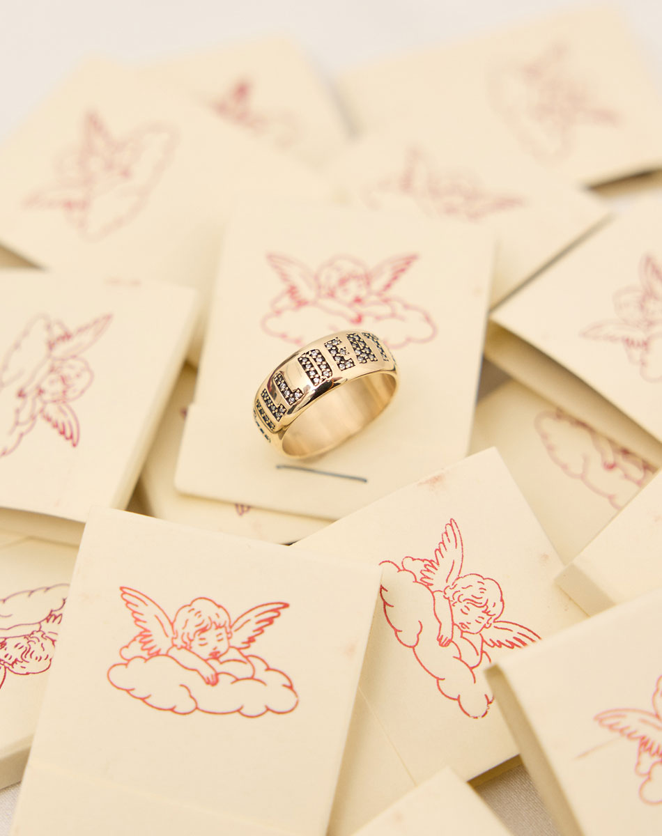 A yellow gold band ring with the phrase 'Till Death' engraved on it and set with white diamonds.