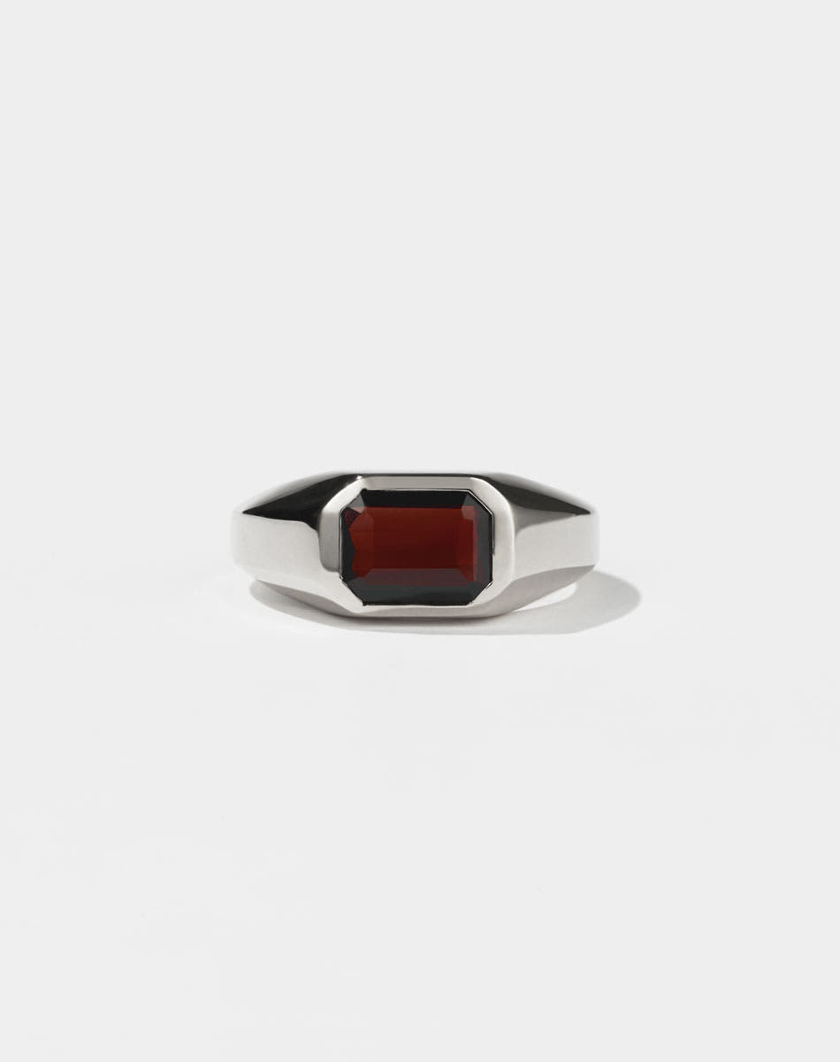 A sterling silver ring with a red Garnet gemstone on a white background. Made by Meadowlark Jewellery in New Zealand.