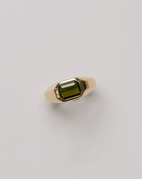A gold ring with a green tourmaline on a white background. Made by Meadowlark in New Zealand.