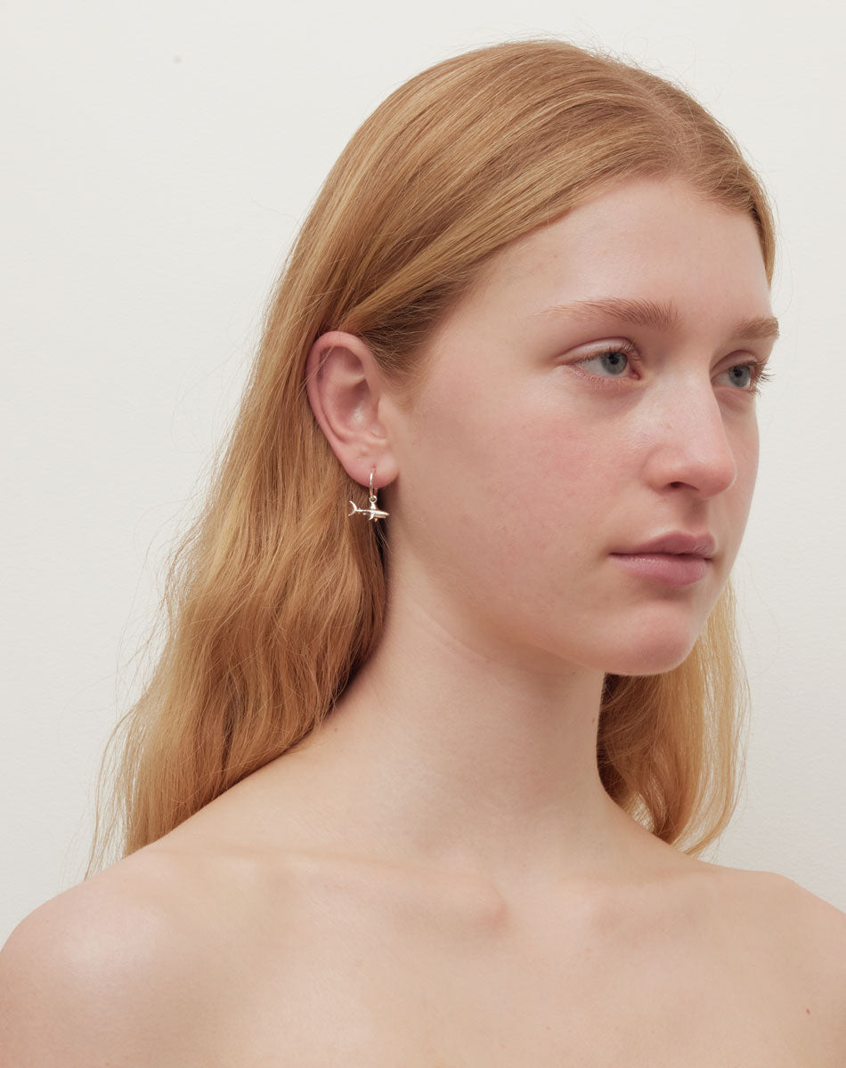 Shark hoop earrings worn on a model