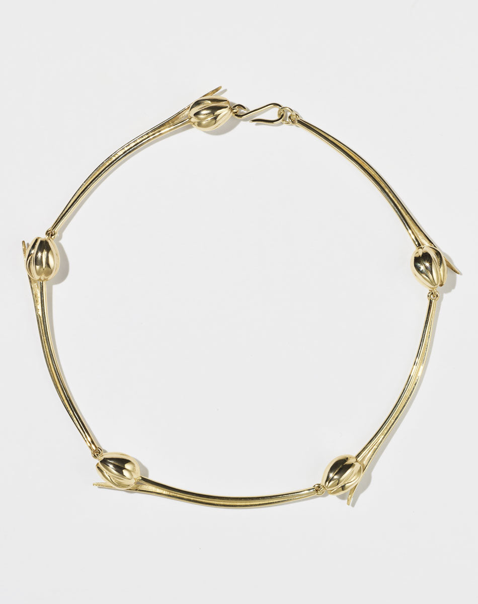 Gold necklace with tulip designs on a white background
