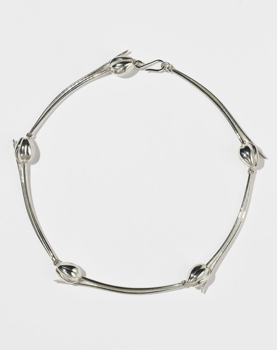 Silver tulip motif necklace on a white background