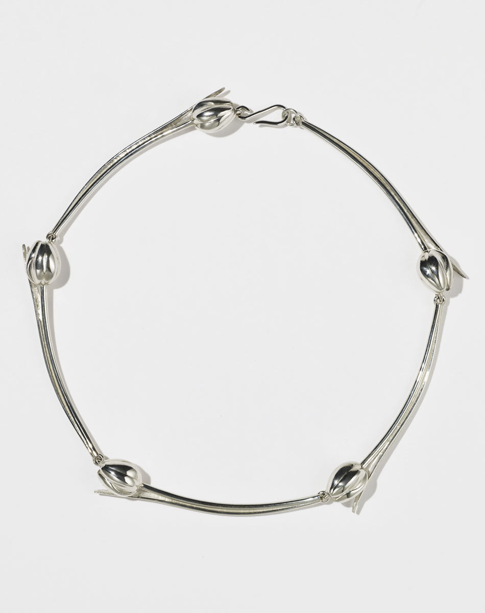 Silver tulip motif necklace on a white background