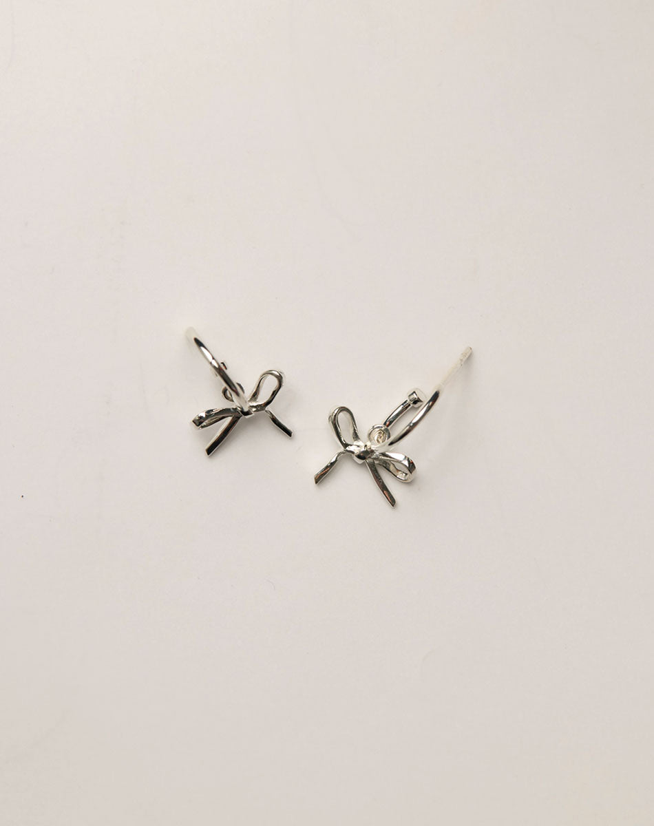Silver bow-shaped earrings on hoops