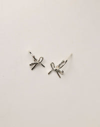 Silver bow-shaped earrings on hoops