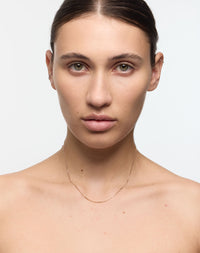 Delicate gold chain worn on a model