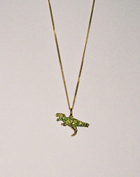 Gold dinosaur pendant necklace with green gemstones  