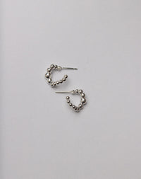 Pair of silver hoop earrings made from a series of bubbly balls
