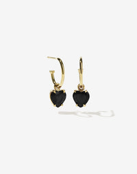 Gold heart-shaped earrings with black onyx stones on a white background