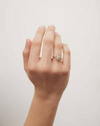 Diamond engagement ring with hexagon halo on a hand.