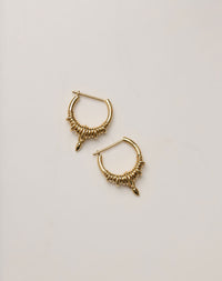 A pair of small hoop earrings made in gold, with a series of rings suspended on a hoop, with small charm. 