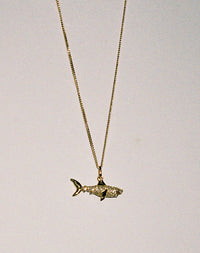 Gold and diamond shark charm pendant necklace.