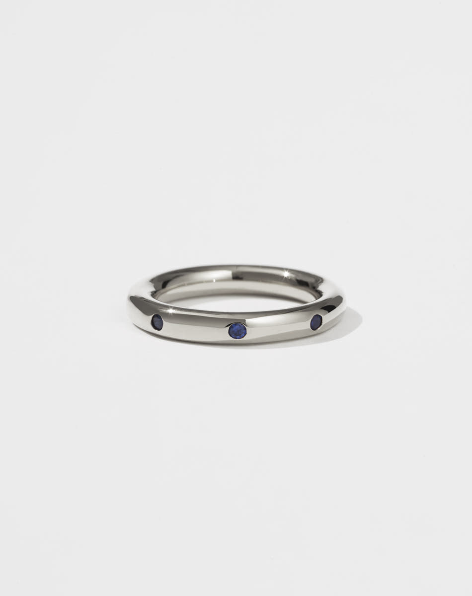 Silver ring with eight blue sapphires set on a white background