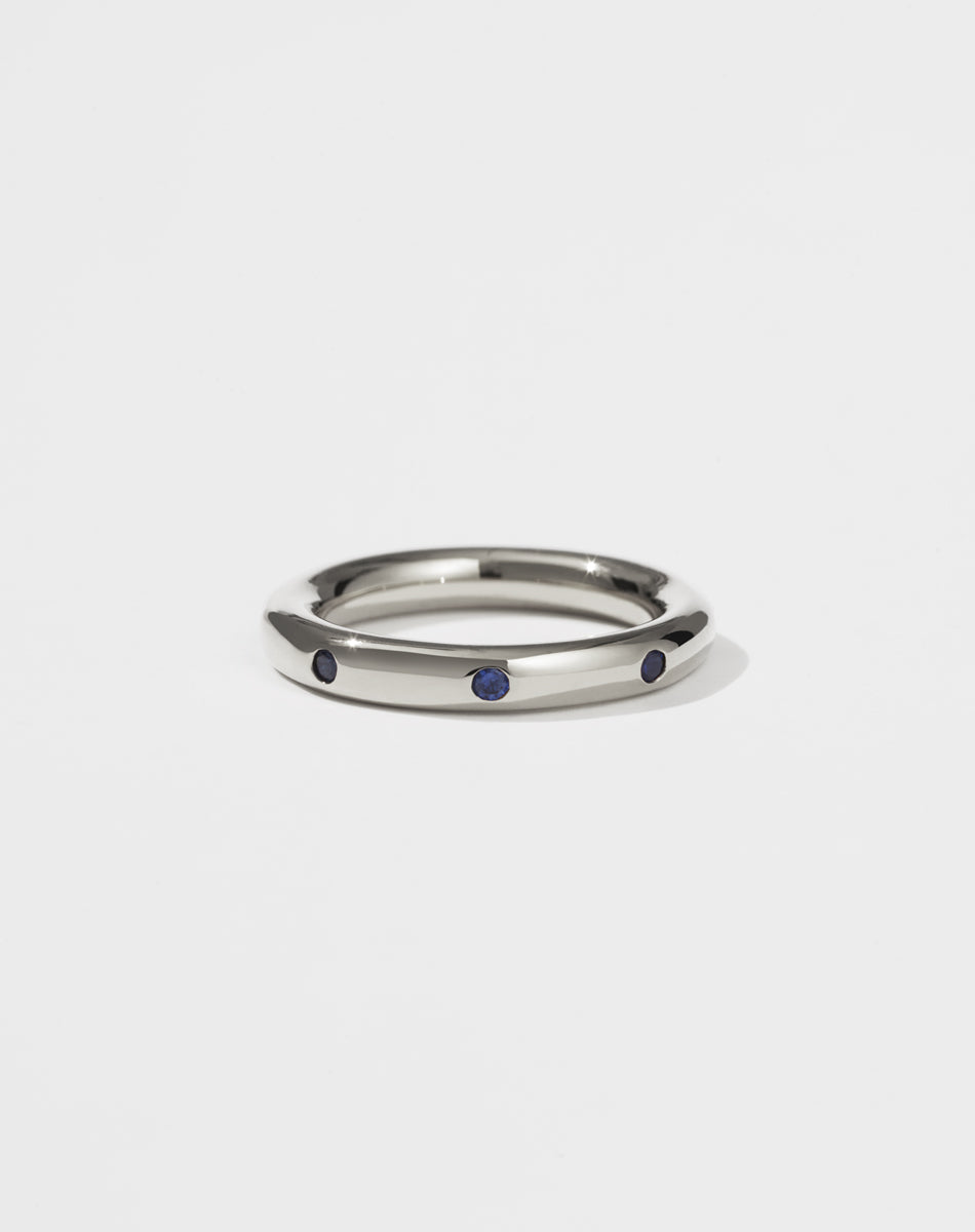 Silver ring with eight blue sapphires set on a white background