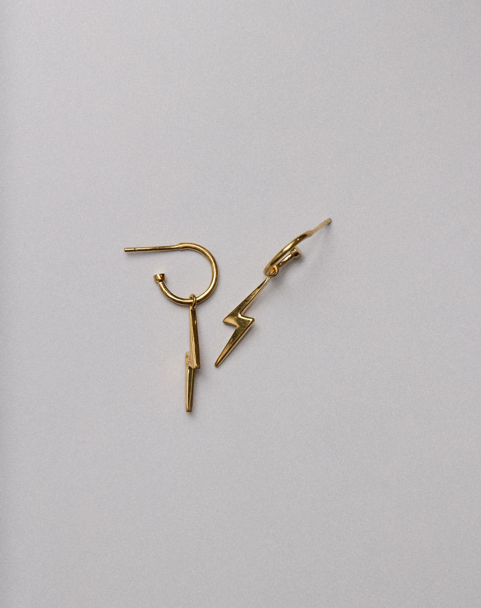 Gold lightning bolt earrings on a white background