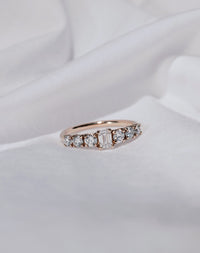 Diamond ring with rose gold band set with seven white diamonds.