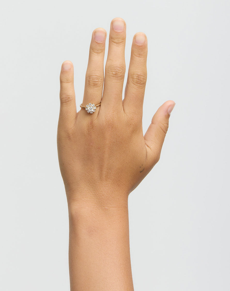 Gold ring with diamonds on a hand on a white background
