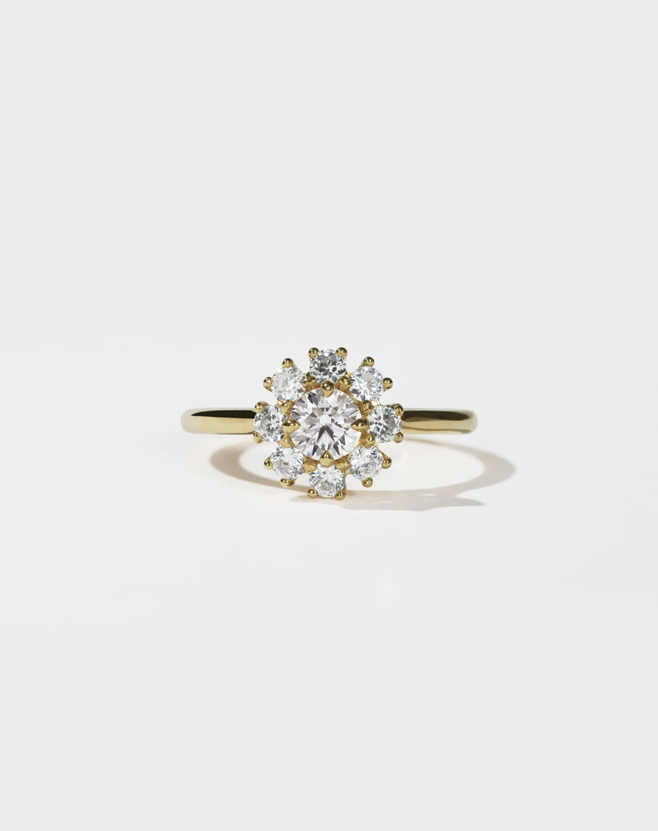 Gold ring with a diamond cluster on a light gray background