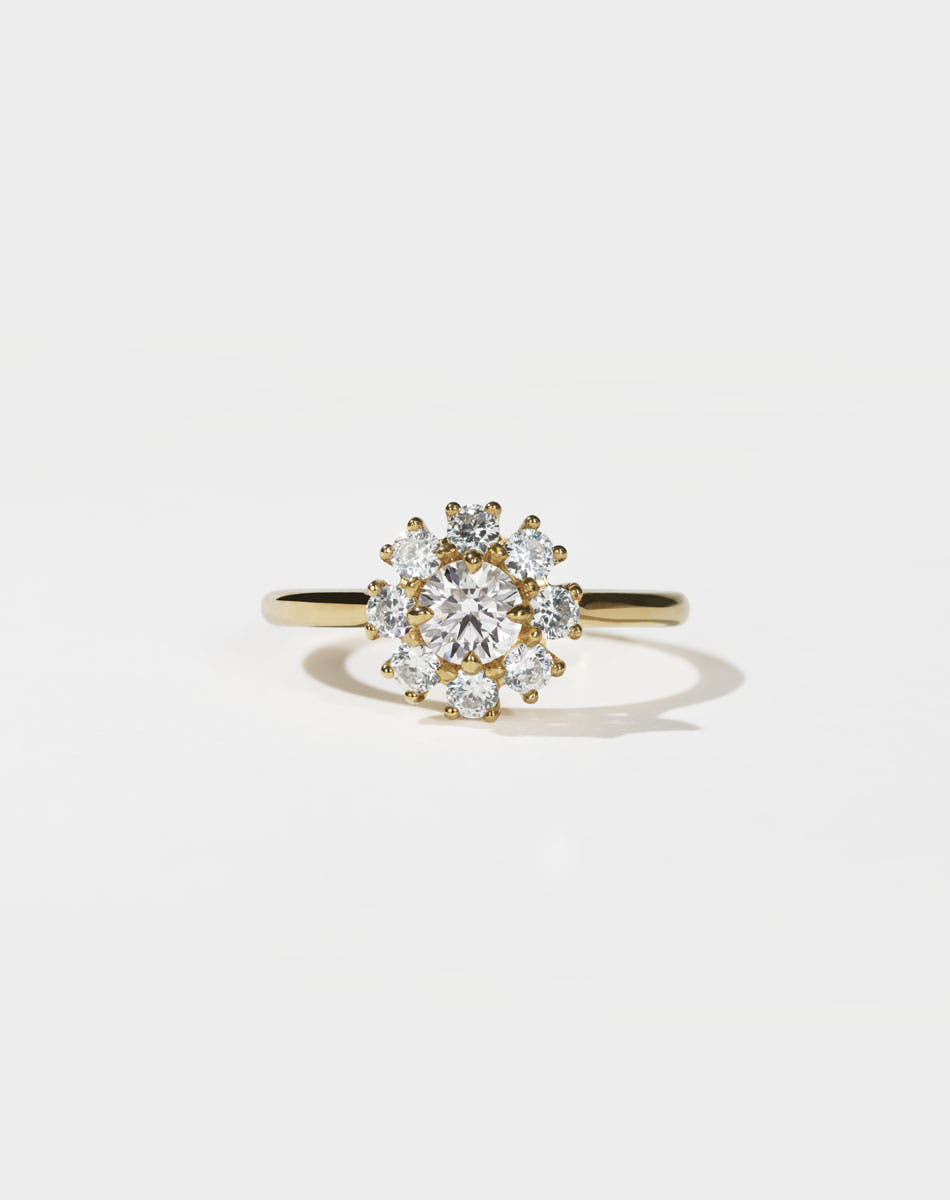 Gold ring with a diamond cluster on a light gray background