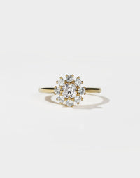 Gold ring with a diamond cluster on a light gray background