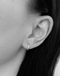 Sterling silver hoop huggie earrings  worn on an ear