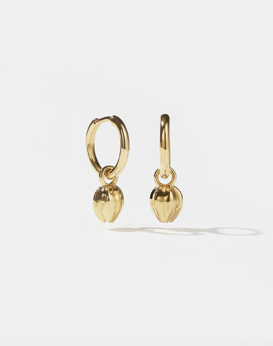 Pair of gold tulip bud charm earrings with on a white background