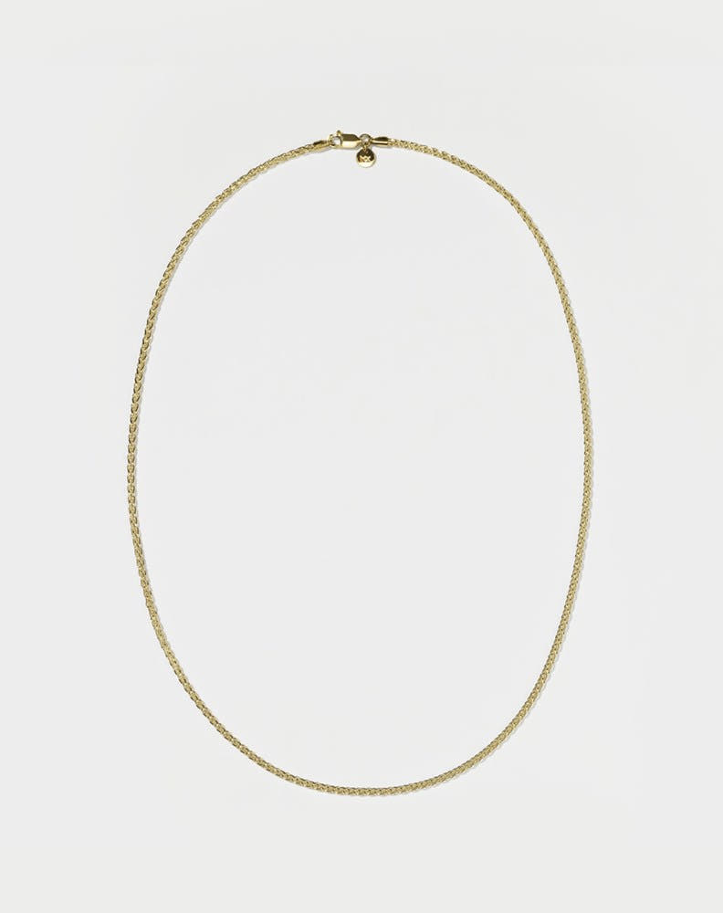 A wheat chain necklace gold plated on a white background.